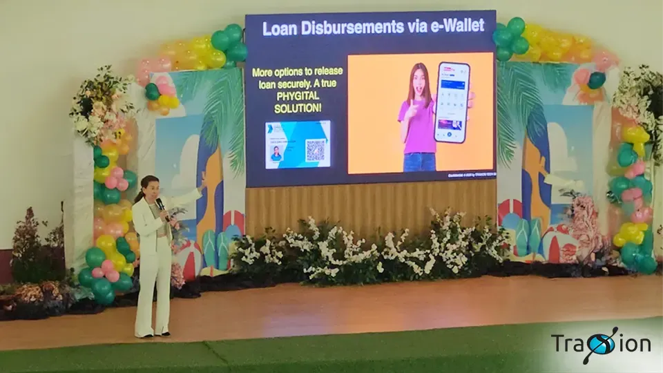 Traxion CEO Ann Cuisia on stage at the Mindanao Microfinance Conference 2025, presenting loan disbursements via e-wallet.